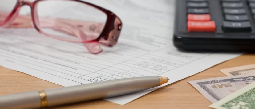 Calculator, pix și document financiar pe un birou