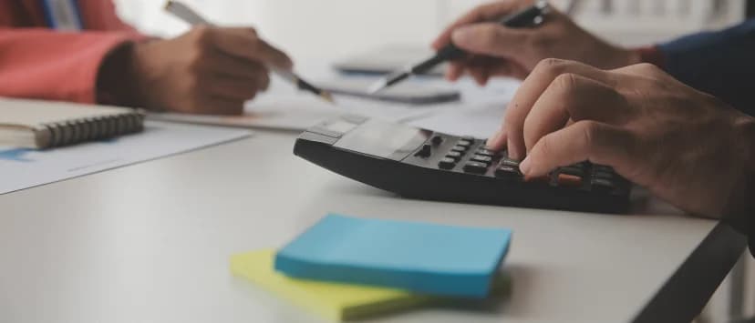 Persoană care calculează valori financiare la laptop